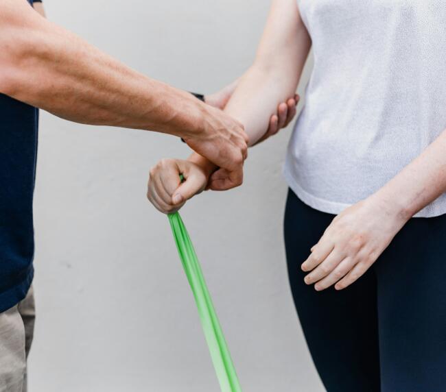 Physiotherapist guiding a patient through a resistance band exercise